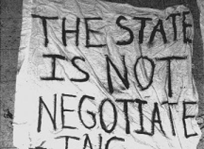 A crudely hand lettered sign on what looks like a sheet saying The state is not negotiating