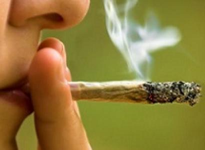 Extreme close up of woman's lips and side of face with a smoking joint held with your fingers at her lips