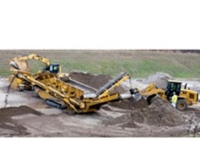 Big yellow construction machine digging into the soil