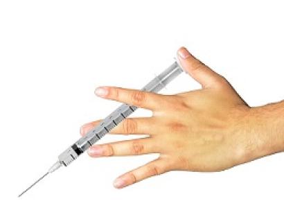 Hand holding a syringe