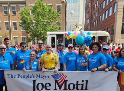 People marching and holding Joe Motil banner