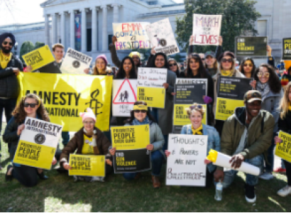People posing outside with Amnesty signs