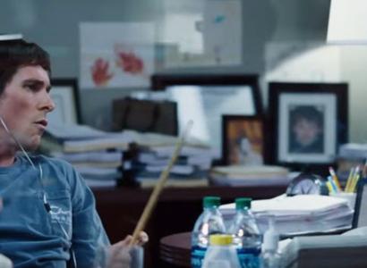 Picture of a guy in an office playing with drumsticks