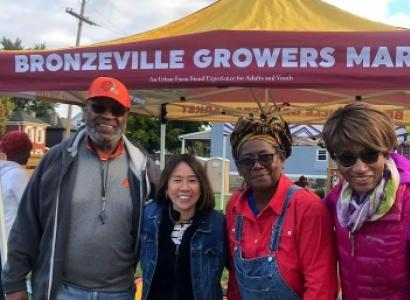 People posing in front of Bronzeville Growers Market booth