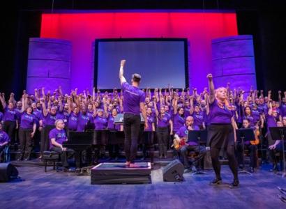 Chorus and conductor with raised fists