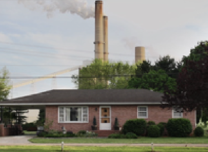 House with coal plant in background
