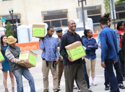 Many people holding boxes