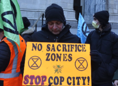 Protestor holding sign saying No Sacrifice Zones, Stop Cop City