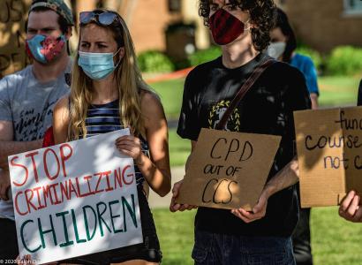 People holding signs saying Stop Criminalizing Children