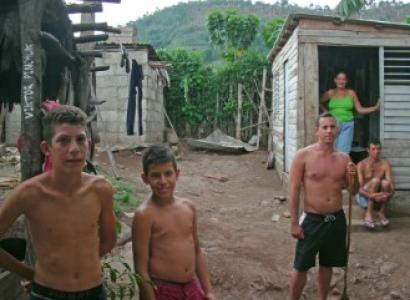 Cuban family standing outside small makeshift house