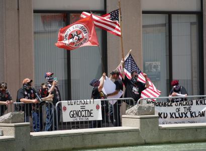 Guys waving flags and with Ku Klux Klan signs