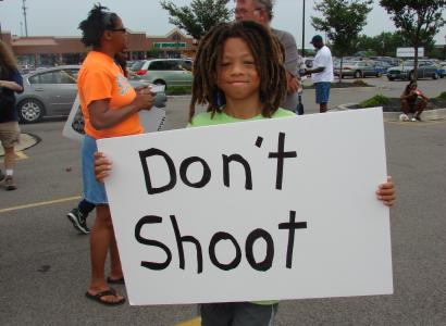 Boy holds sign that says Don't Shoot