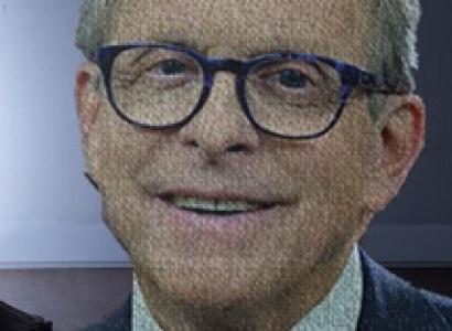 Smiling older white man wearing round black-rimmed glasses