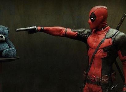 Deadpool character pointing a gun at a teddy bear