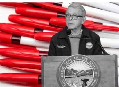 Governor Dewine at a podium in front of red pens