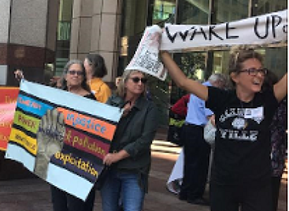 People outside holding banners one saying Wake Up