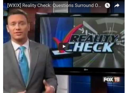 Screenshot of white male newscaster next to a screen with the words Reality Check with a big red checkmark