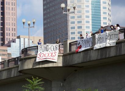 Fund Schools sign hung on overpass