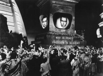 People raising fists to a man's image with words War is Peace