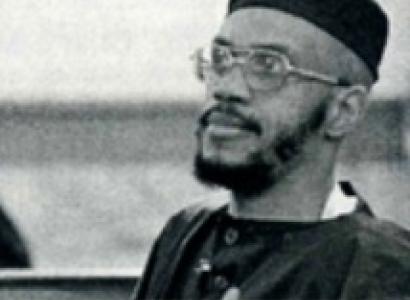 Black and white photo of black man in muslim outfit, glasses and a beard