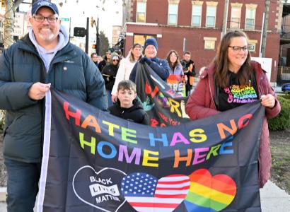People marching with banner saying Hate has no home here