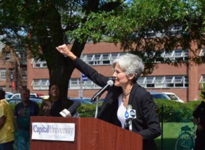 Jill Stein raising her fist at the podium