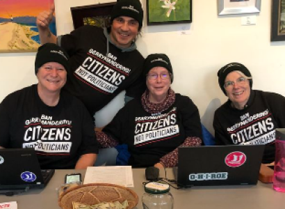 Four people posing at a desk