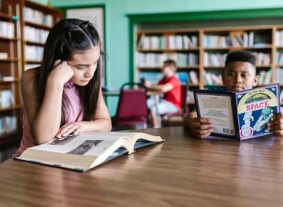 Kids reading at table in library