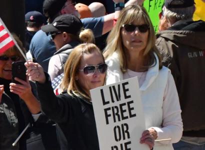 Woman holding sign saying Live Free or Die