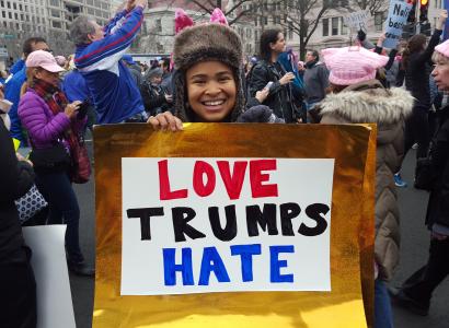 Young woman holding Love Trumps Hate sign