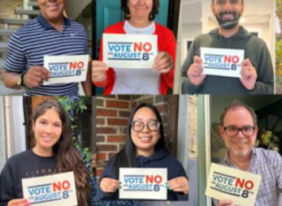 People holding signs saying Vote No on Issue One