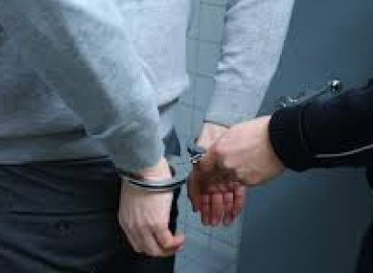 Back of white man with white cop hand putting handcuffs on him