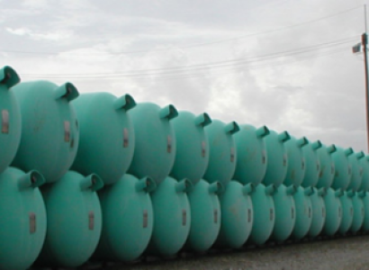 Dozens of blue green barrels lined up