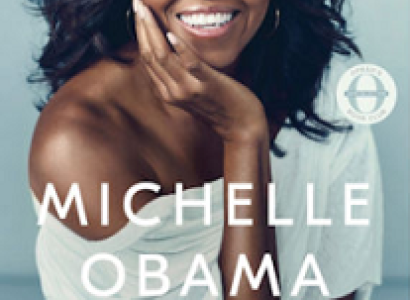 Pretty black woman smiling with long black hair waving in the wind wearing a white shirt that is off one shoulder and words Becoming at top and MIchelle Obama below