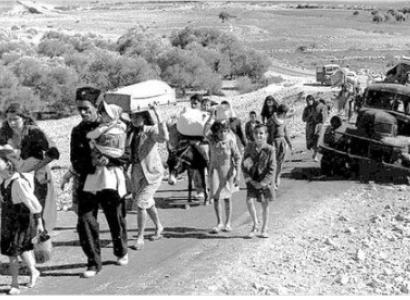Families walking down a road with all their belongings