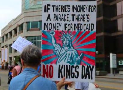 Protester holding sign saying If there's money for a parade there's money for Medicaid