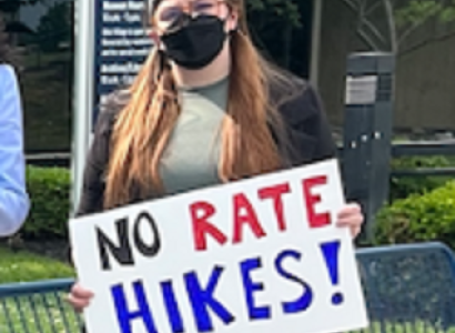 Woman holding No Rate Hikes sign