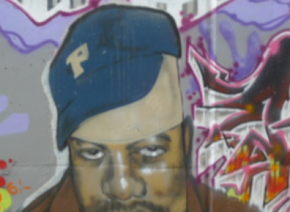 A black man wearing a blue baseball cap looking sad