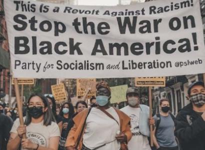 People marching in street with a banner