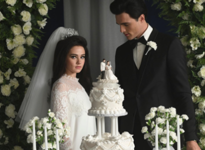 Priscilla and Elvis at wedding in front of wedding cake