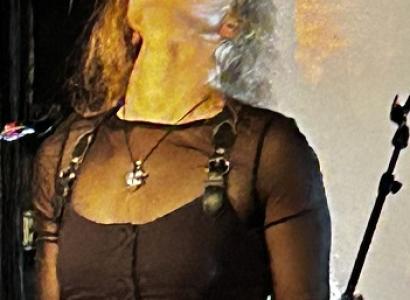 Blonde woman in black outfit with her head back and eyes closed