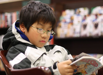 An asian boy reading GRAPHiC N0VEL in a Barnes & Noble bookstore in West Hartford, Connecticut