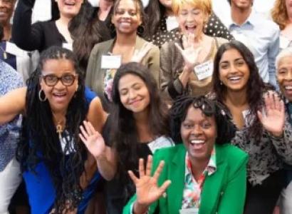 Lots of people smiling and waving at the camera