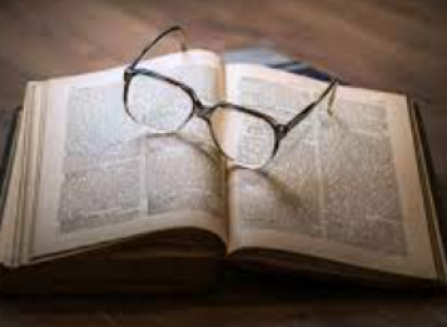 Open book with glasses lying on it