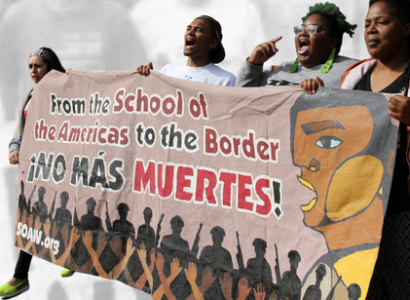 Women holding banner about closing SOA and yelling