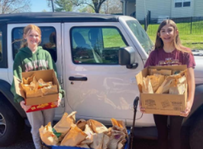 People posing with sack lunches