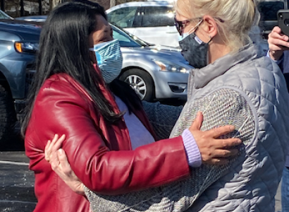 Miriam embracing another person