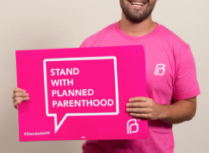 Man holding a sign saying Stand with Planned Parenthood