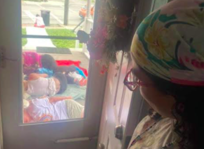 Looking out a window of women sleeping on the ground