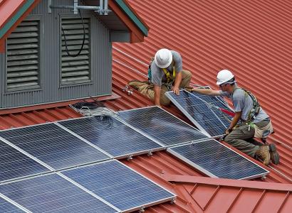 Men installiing solar panels on a roof